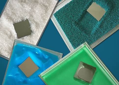The photograph shows a square-shaped intruder plunging through various material, including coarse, salt-like grains (white) and fine sand (blueish green), as well as more viscous (green) and pasty (blue) materials. Image courtesy: Felice Frankel, MIT