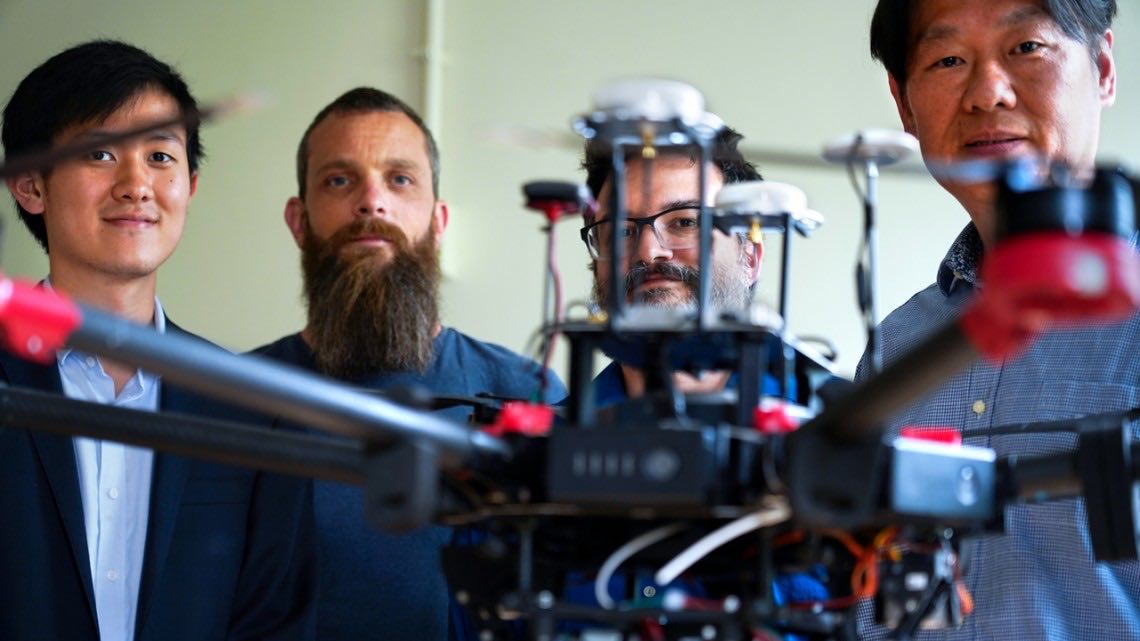 Cornell University researchers are using an aerial drone used to monitor plants from above. From left: Nathan Zheng; postdoctoral researcher Ethan Stewart; Michael Gore, Ph.D., professor of molecular breeding and genetics for nutritional quality; and David T. Shen. Courtesy: John Munson, Cornell University