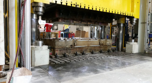 Figure 2: The moving platen (yellow structure) is visible above the fixed lower bolster of the 2,430-ton Hoesch press. Courtesy: Delta Computer Systems Inc.