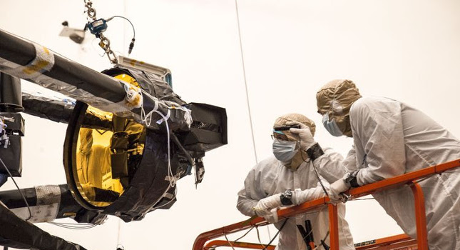 Engineers Perry Knollenberg (left) and Paul Reynolds (right) inspecting Webb’s secondary mirror’s outboard hinge at Northrop Grumman’s clean room in Redondo Beach, California. Courtesy: Northrop Grumman
