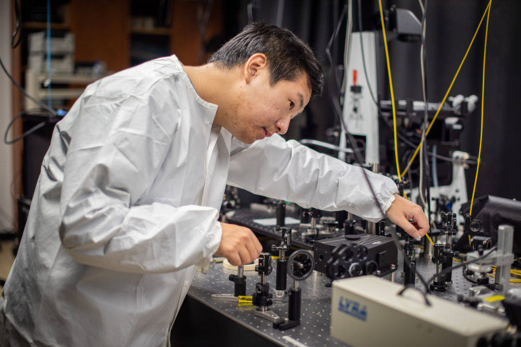 Zidong Li aligns the optical setup used to generate excitons on the chip. The new technology paves the way for transporting energy efficiently with excitons. Courtesy: Silvia Cardarelli, University of Michigan