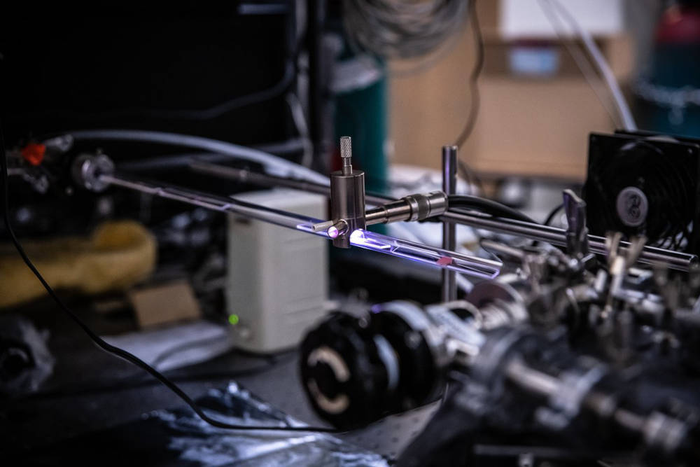 A ray of plasma, which glows pink, is used to activate a gas of hydrogen and methane molecules and break them down into smaller fragments. The sample to be coated, such as a two-dimensional copper line, is then immersed in the plasma, and carbon from the gas gets deposited onto the surface as thin sheets of graphene. Courtesy: Caltech