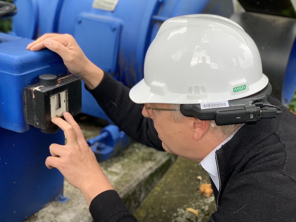 TÜV SÜD inspector conducts a visual inspection of the oil pressure adjustment of an emergency power generator. VR-Glasses VR-Glasses from manufacturer RealWear has earphones for noisy environments. Courtesy: TÜV SÜD