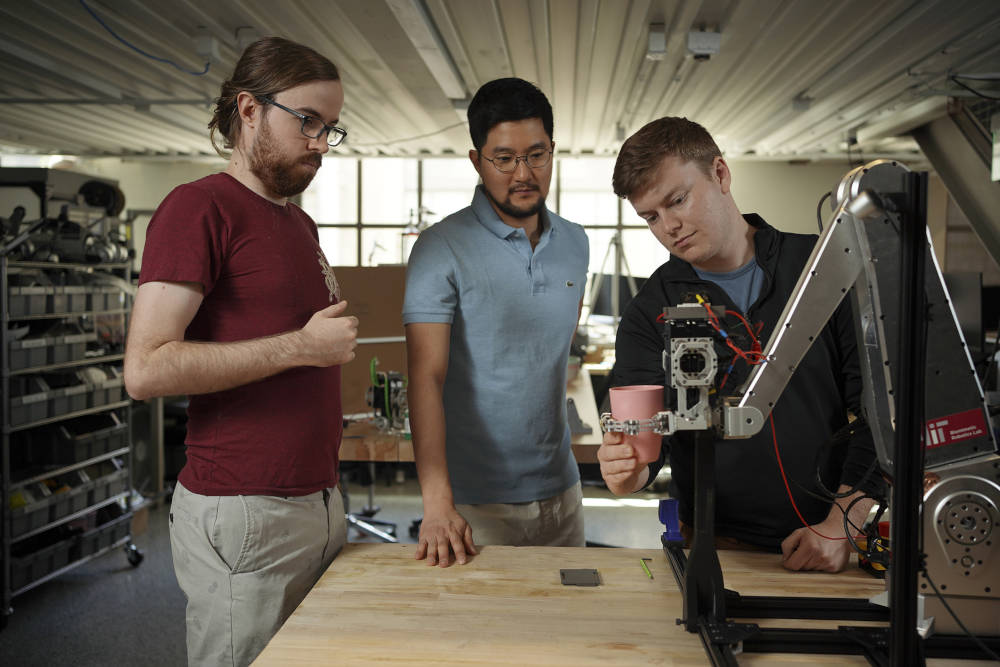 MIT researchers (from left): Elijah Stanger-Jones, Hongmin Kim, and Andrew SaLoutos have designed a robot gripper that incorporates reflexes to quickly grasp and sort everyday objects. Courtesy: Jodi Hilton, MIT