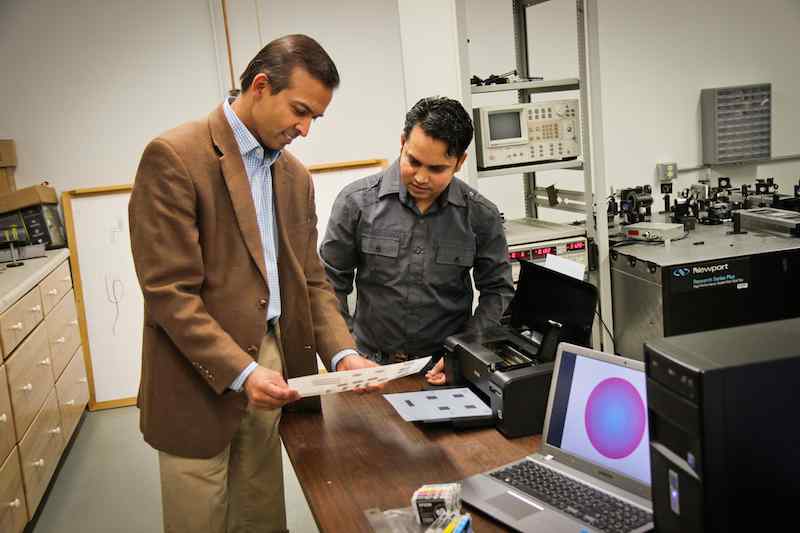 University of Utah electrical engineers Ajay Nahata (left) and Barun Gupta (right) used a $60 inkjet printer with silver and carbon ink cartridges to create a new, widely applicable way to make microscopic structures that use light in metals to carry info